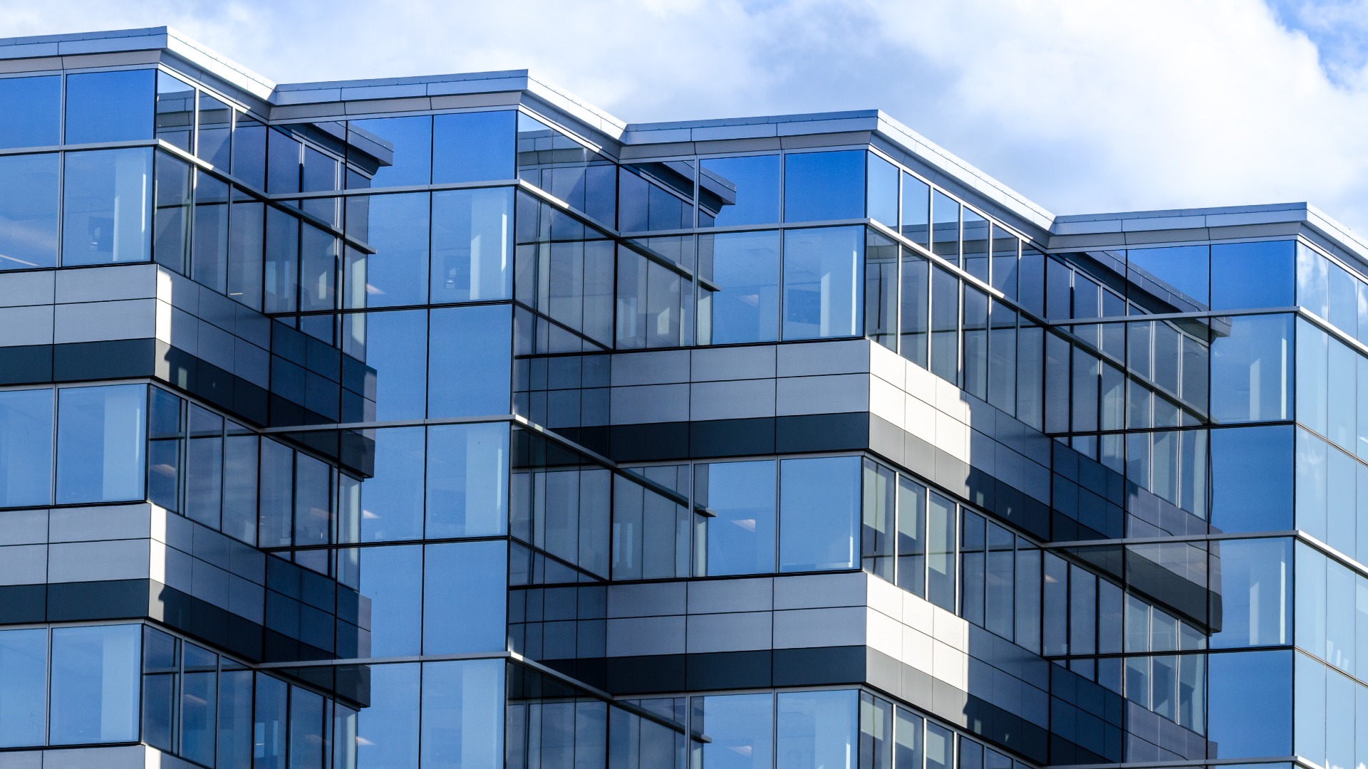 Lines, glass and reflections of modern architecture.  Glass panelled building of new office space in Moncton, New Brunswick.  
New commercial real estate in the city.